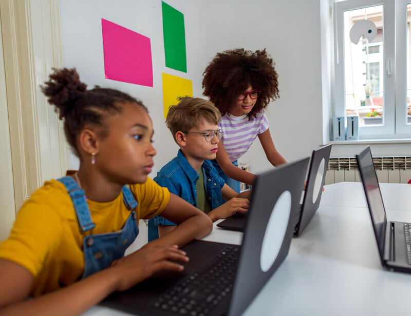 Children learning together on laptops during a live online class