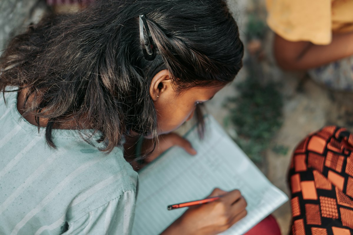 A girl writing carefully in her notebook
